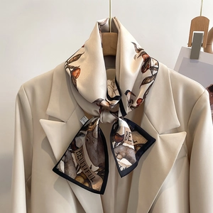Elegant beige silk scarf with paisley bird print worn on a stylish beige blazer neck