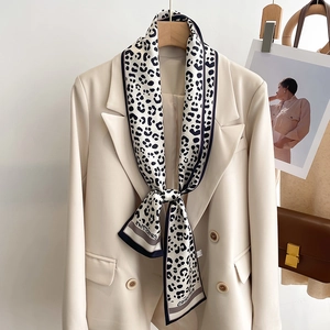 Fashionable leopard print narrow silk scarf styled on a chic double-breasted suit jacket