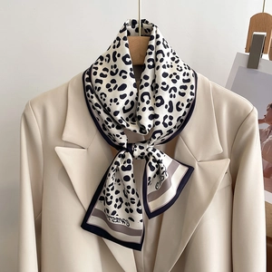 Detail of leopard print satin scarf with striped border and elegant script text
