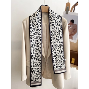 Detail of a leopard print silk scarf styled on a beige blazer for a French fashion look