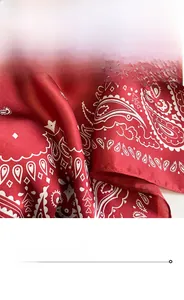 Close-up of red paisley silk scarf with detailed stitching and smooth satin texture