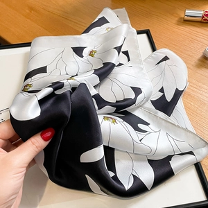 Silk scarf with white magnolia floral print on black background with satin finish
