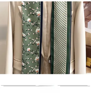 Détail d'un foulard en soie vert à fleurs et rayures sur un blazer beige chic