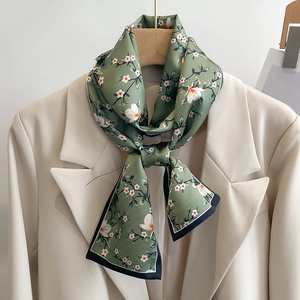 Écharpe étroite fleurie vert sauge nouée sur un blazer crème pour un style通勤 élégant