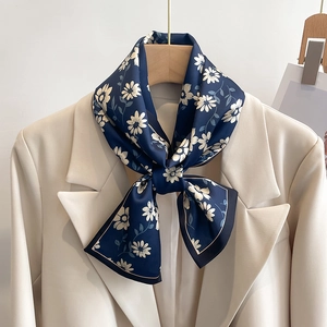 Élégant foulard en satin bleu marine à imprimé marguerites sur un blazer ivoire