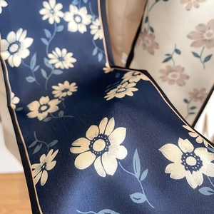 Vue détaillée de foulards en soie à imprimé marguerites avec une texture lisse et bordure