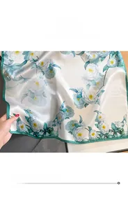 Detailed close-up of fine hemmed edges and floral print on mulberry silk scarf