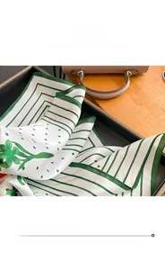 Détail d'un carré de soie avec fleurs vertes à pois et coutures de bordure précises