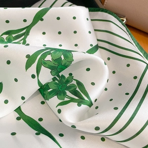 Carré en soie à pois verts et motif floral avec texture soyeuse et reflets élégants