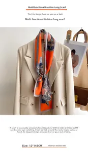 Gros plan d'un foulard en soie orange 12x148cm noué sur le col d'un blazer