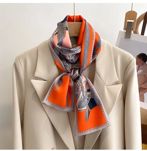 Détail d'un foulard en soie imprimé avec motif harnais sur un blazer blanc