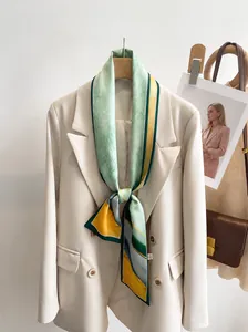 Detailed view of long silk scarf styled with blazer featuring 12x148cm green abstract pattern