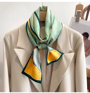 Close-up of silk scarf with geometric oil painting print styled on a beige blazer collar
