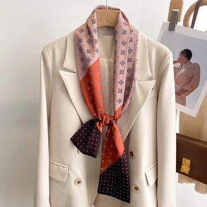 Foulard en soie chic à motifs géométriques et pois porté sur un blazer blanc