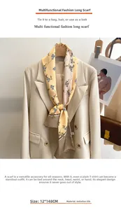 Détail d'une écharpe étroite en imitation soie jaune clair fleurie sur un blazer