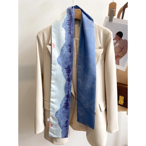 Detail view of long silk scarf with oil painting landscape on a beige blazer