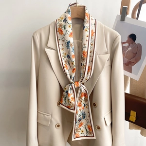 Écharpe étroite en soie à fleurs nouée sur un blazer beige pour un look chic femme