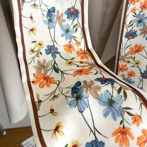 Détail d'une écharpe en polyester de 140 cm avec imprimés floraux et bordures marron