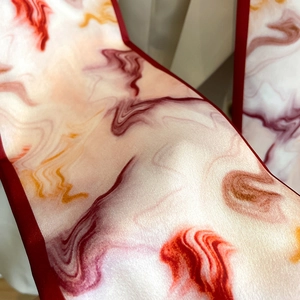 Detail shot of silk-like scarf with abstract marble pattern and satin glossy finish