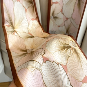 Détail d'un foulard en soie à fleurs avec bords cousus main et motif floral rose