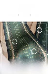 Détail d'un foulard en soie vert foncé avec texture satinée et imprimé géométrique