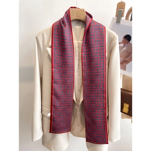 Vue détaillée d'une écharpe en soie à motif géométrique rouge et bleu sur un blazer
