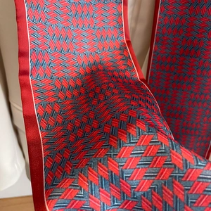Gros plan d'un foulard en soie aux motifs géométriques rouge-bleu et texture soyeuse