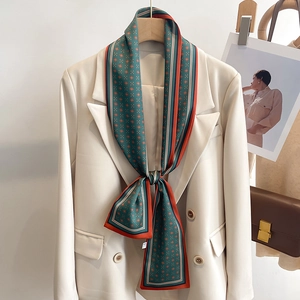 Foulard étroit en soie vert foncé avec motif floral orange sur revers de blazer