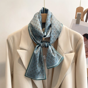 Détail macro d'un foulard en soie bleu clair à motifs géométriques sur un blazer