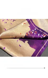 Detailed close-up of high-quality silk scarf edge stitching and purple floral pattern