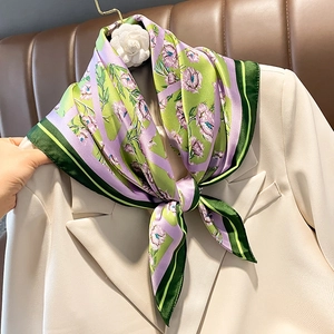 Elegante foulard in seta a fiori viola annodato sul bavero di un blazer bianco