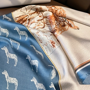 Detailaufnahme eines Vintage-Seidenschals mit Zebramuster und Waldmotiven am Taschengriff