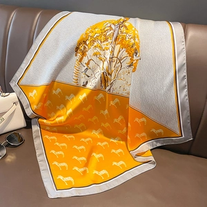 Detailansicht eines Seidentuches mit orangem Zebramuster auf einem Ledersofa