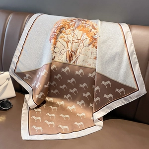 Detail eines Seidensatin-Schals mit Zebra-Muster auf einem Ledersofa drapiert