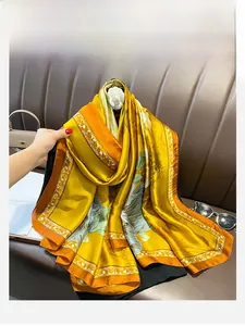 Dettaglio di una sciarpa di seta gialla a fiori su sfondo di pelle marrone