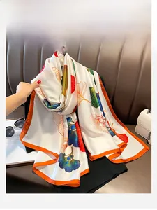 Detail of silk scarf with orange borders and gradient ginkgo leaf patterns in close-up