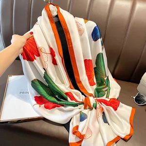 Elegant white silk scarf with colorful ginkgo leaf print and orange rolled edges