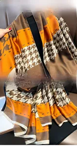 Detail of silk-like scarf featuring houndstooth pattern and precise hem stitching quality