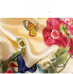 Macro detail of silk-like scarf featuring golden fabric with red peony and butterfly prints