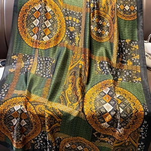 Luxurious oversized floral paisley print silk scarf draped over a classic leather chair