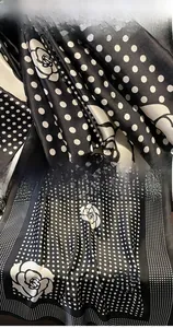Detail of camellia floral silk scarf featuring polka dots and premium stitched edges