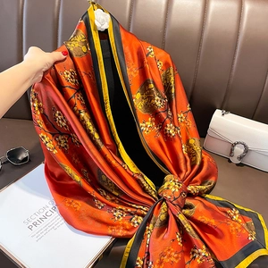 Élégante écharpe en soie rouge à imprimé floral chinois drapée sur un canapé chic