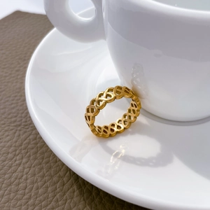 Dettaglio dell'anello in acciaio al titanio placcato oro 18K con cuori traforati intrecciati