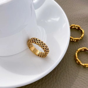 Primo piano di tre anelli a cuore in maglia e catena placcati in oro 18 carati su ceramica