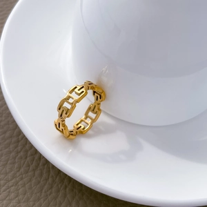 Dettaglio macro dell'anello in titanio placcato oro 18K con motivo a cuore a rete