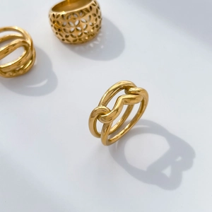 Macro view of interwoven 18K gold plated titanium ring with hollow twisted line texture
