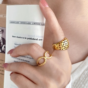 Detailed close-up of 18K gold plated hollow patterned and twisted rope ring set