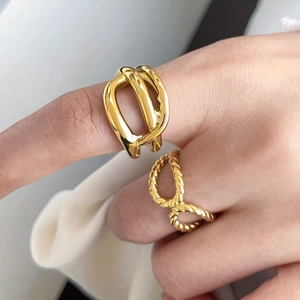 Close-up of 18K gold plated wide abstract and twisted rope rings on a model hand