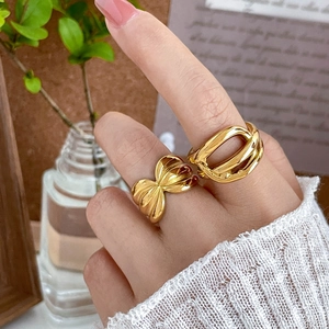 Detail of 18K gold-plated chunky twist rings with a bow and hollow chain design