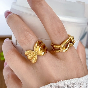 Wide 18K gold plated hollow abstract twisted rope rings shown in a lifestyle daily setting